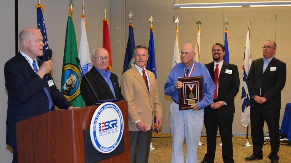 Jim Rabideau holds the James M. Roche Spirit of Volunteerism Award. To his right are his sons Samuel and Thomas Rabideau. He was honored in 2016 for his volunteer work promoting employer support of members of the National Guard and Reserve.