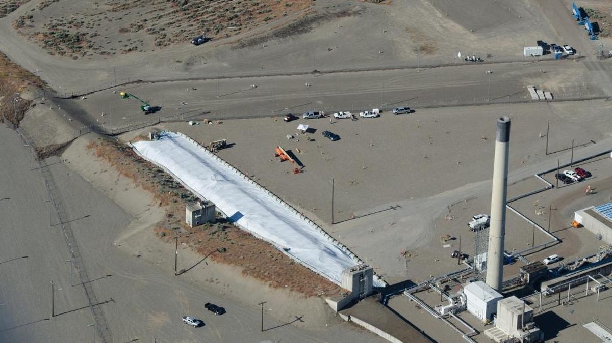 The partially collapsed waste-storage tunnel at Hanford has been temporarily covered with heavy plastic and next will be filled with grout to further stabilize it. Beside it runs a longer waste-storage tunnel.
