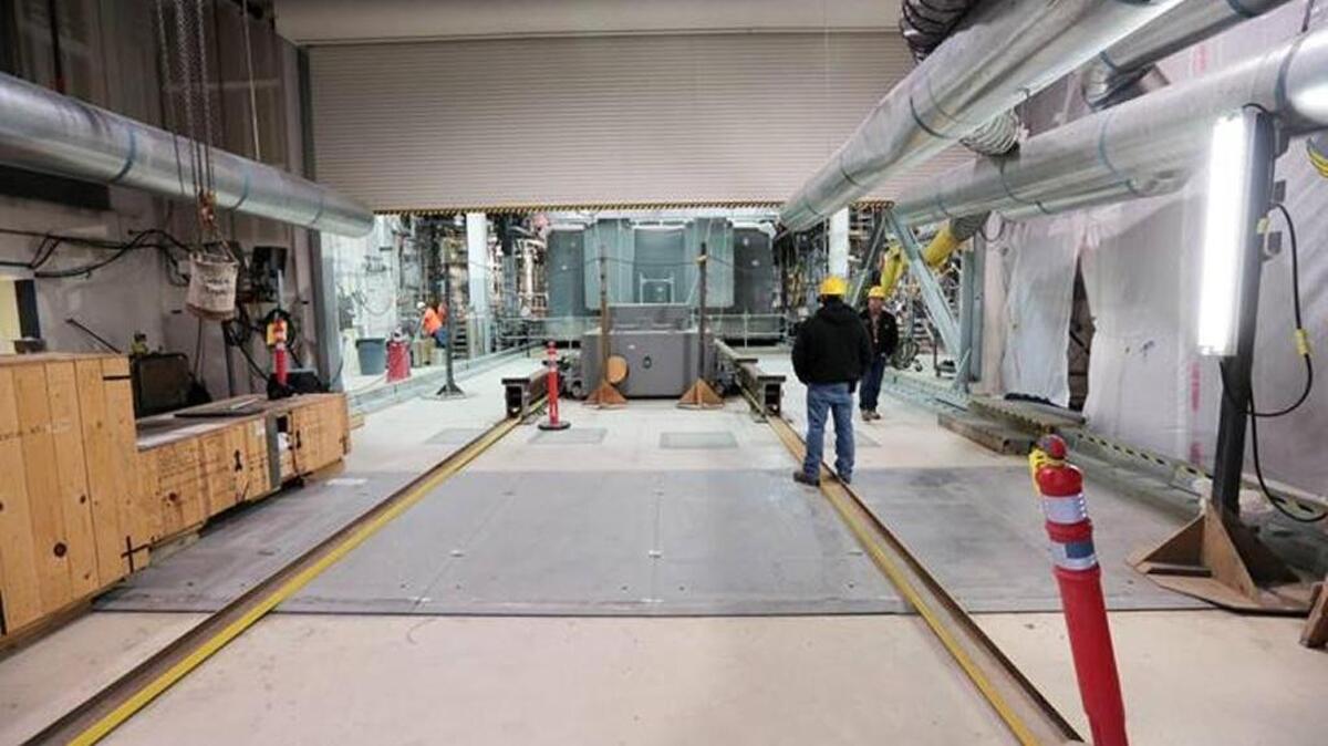 Employees walk through the melter bay area of the Hanford vitrification plant’s Low Activity Waste Facility.