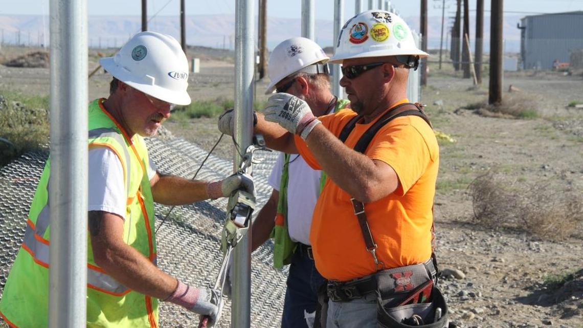 
Subcontractor employees install a fence around the Hanford Plutonium Finishing Plant to control access during demolition of the plant.
