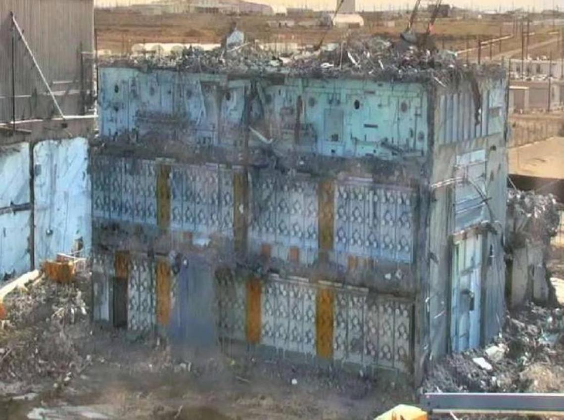 Part of the Plutonium Reclamation Facility at one end of the Hanford Plutonium Finishing Plant has been partly demolished. Blue fixative is sprayed on the building during demolition to help prevent airborne contamination.