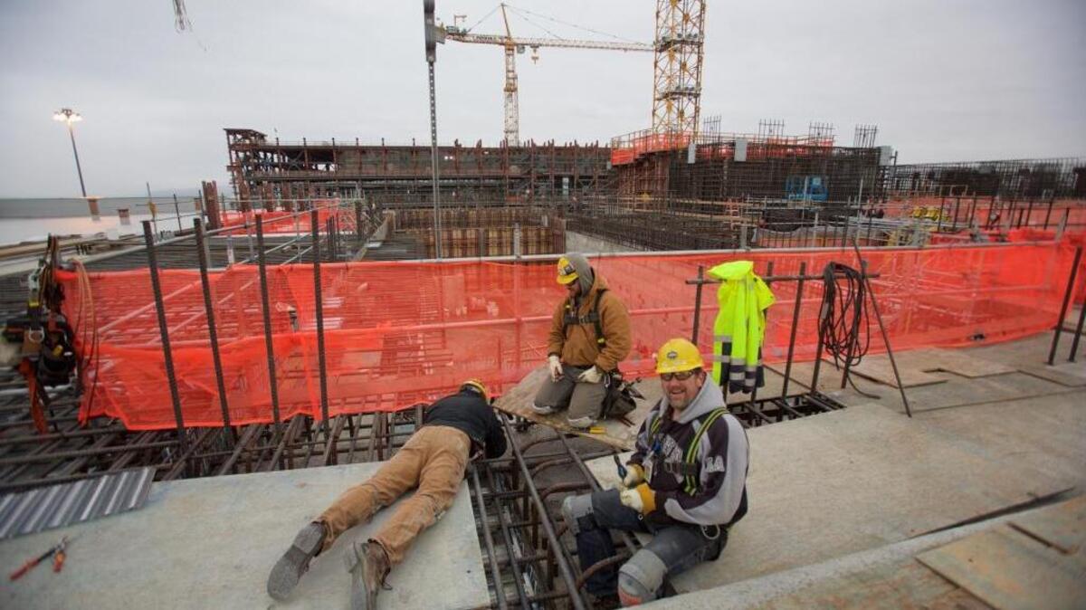Employees at the High Level Waste Facility of the Hanford nuclear reservation’s vitrification plant use wooden planks as platforms as they install rebar flooring and decking underneath.