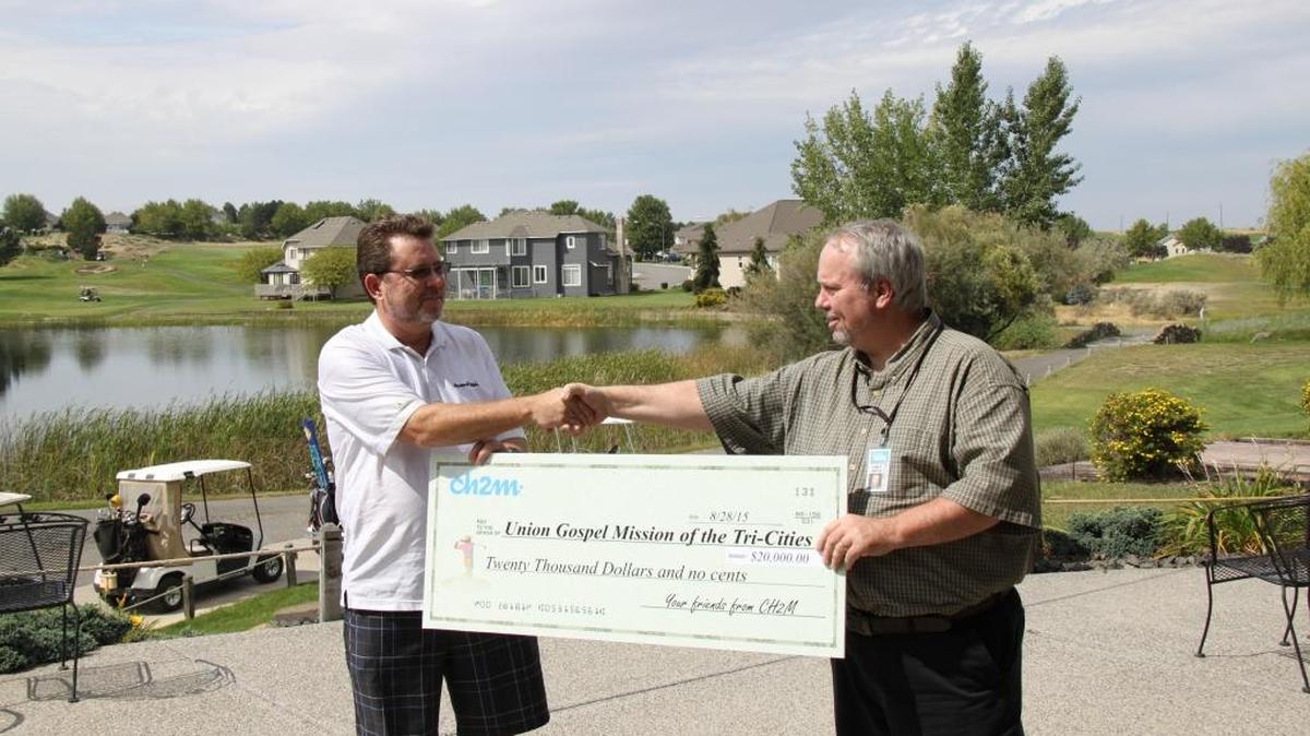 
John Ciucci, left, president of CH2M Hill Plateau Remediation Co., presents Tri-City Union Gospel Mission director Andrew Porter, right, a check for $20,000 following CH2M's annual golf tournament at Horn Rapids Golf Course.
