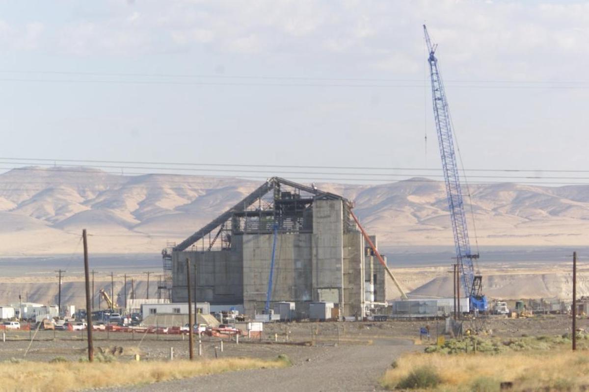Hanford employees work on installing a roof over the now–cocooned DR Reactor at Hanford.