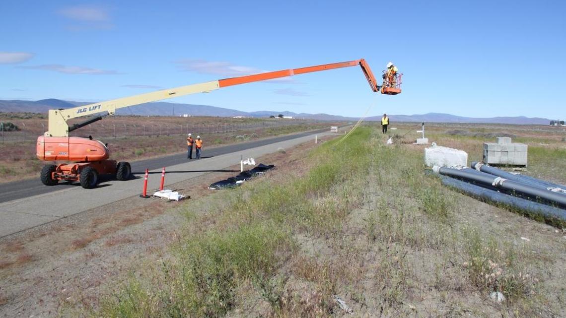 Hanford workers practice the method that will be used for covering a breached waste tunnel with heavy plastic.
