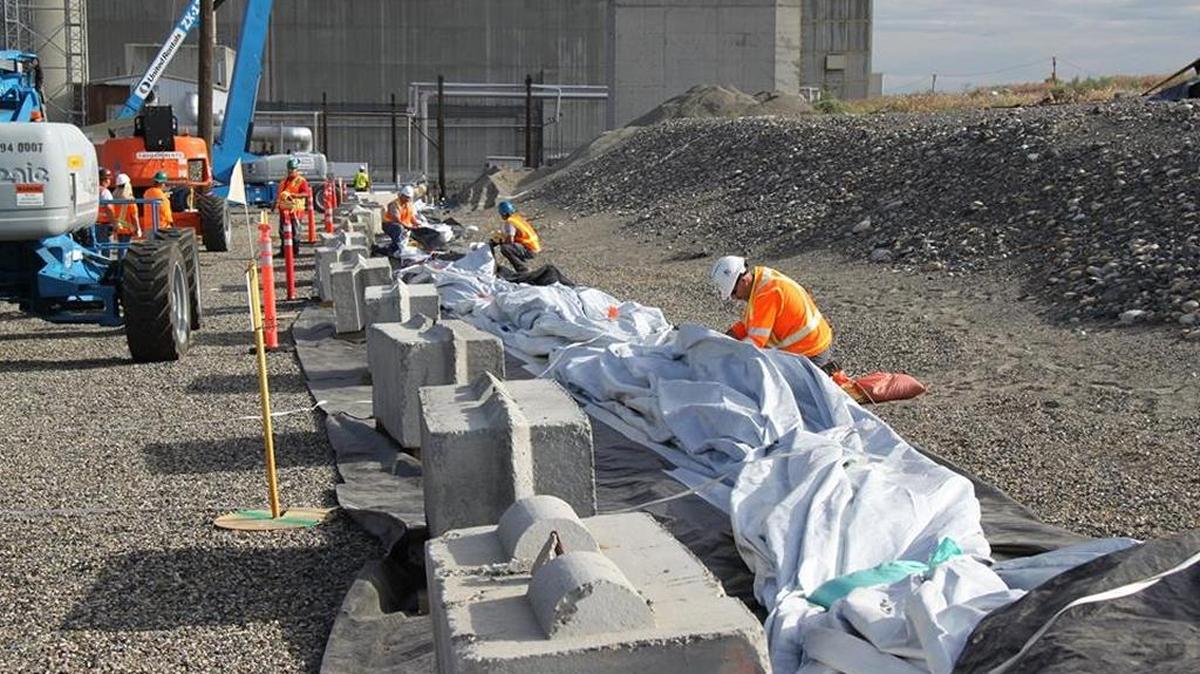 Workers lay out a 40,000-square-foot piece of heavy plastic to cover the breached PUREX plant waste tunnel at Hanford. Congressional members representing the Tri-Cities say the partially collapsed tunnels illustrate the need for strong Hanford funding.