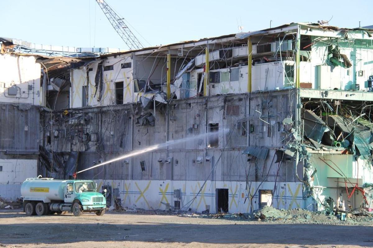 A truck sprays fixative on demolition debris at the Plutonium Finishing Plant with a goal of preventing radioactive particles from becoming airborne.