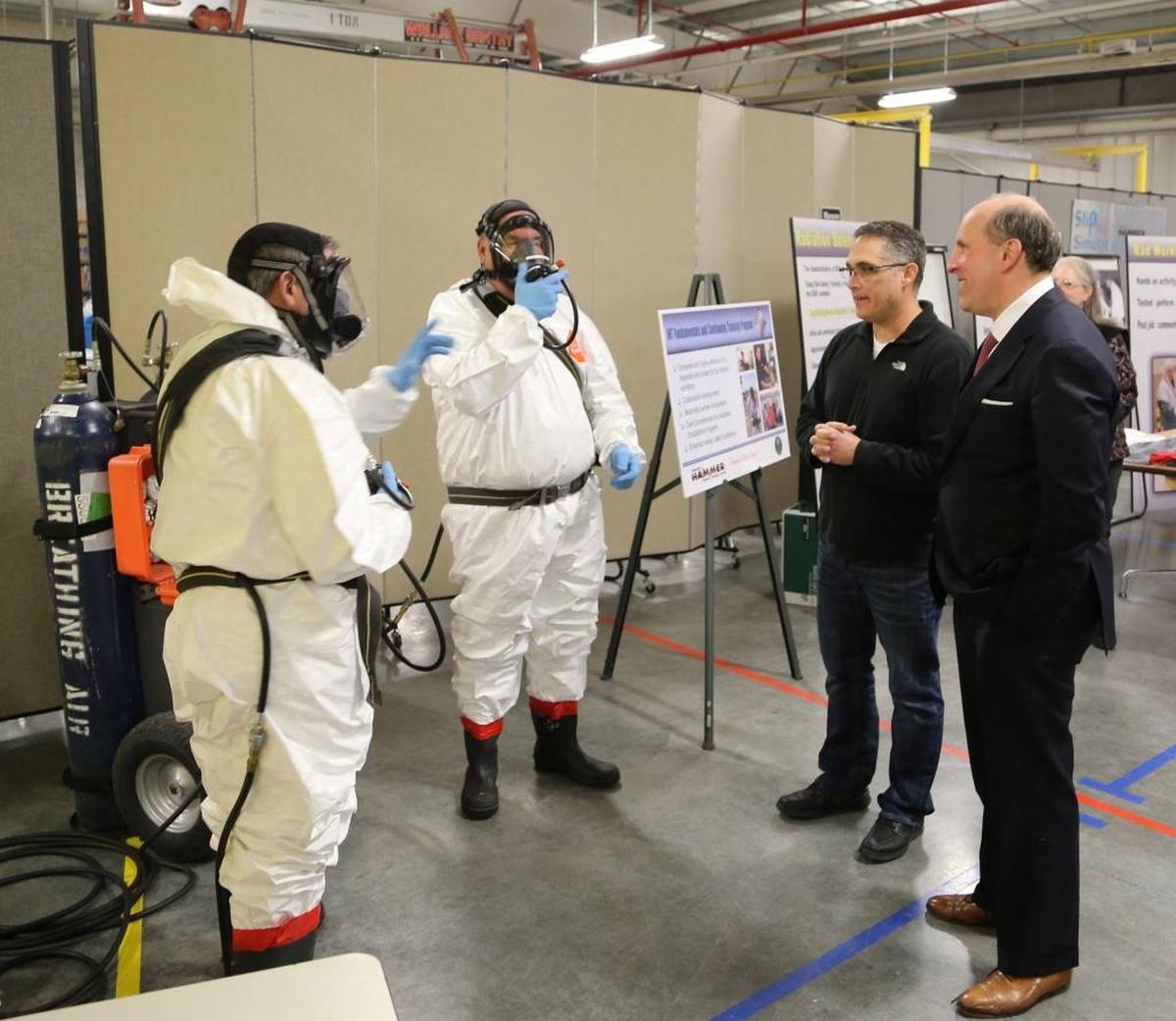 Paul Dabbar, right, the Department of Energy undersecretary for science, tours the HAMMER training facility and watches a respiratory demonstration led by two worker trainers on how to respond to a loss of air.