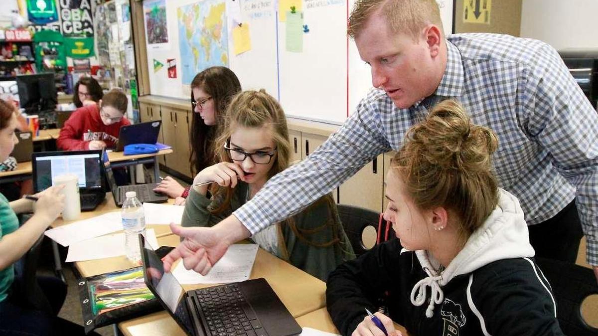 Richland High School teacher Nick White answers a question for Kelsey Wallace, left, and Abreese Ungard during a U.S. Government class. The Richland School District was among local government agencies receiving full payment in lieu of taxes from the Department of Energy after DOE initially was short of money.