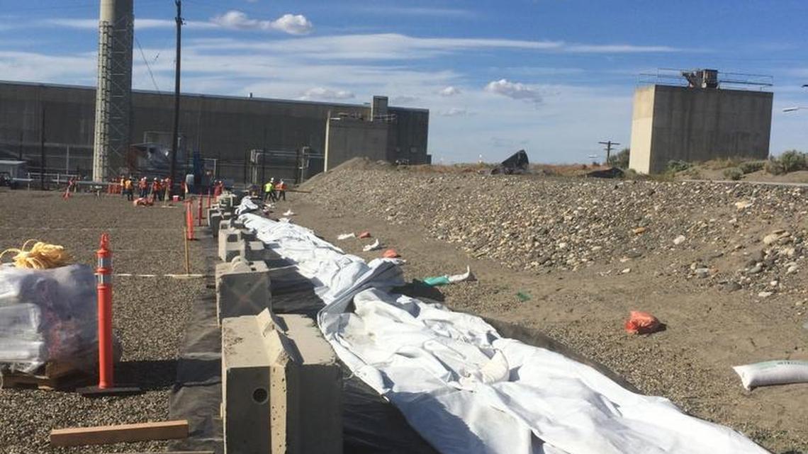 Workers staged a 400-foot-long piece of heavy plastic on Friday along the partially collapsed waste tunnel at the PUREX plant at the Hanford nuclear reservation. The tunnel is expected to be covered on Saturday.