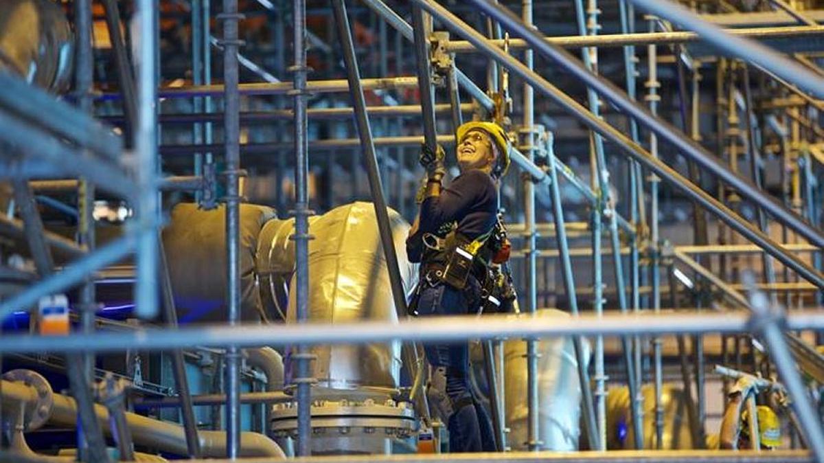 An employee smiles as she installs scaffolding around equipment in the chiller compressor plant of the Hanford vitrification plant. Sen. Maria Cantwell, D-Wash., told the incoming presidential administration that work must be completed on the plant.