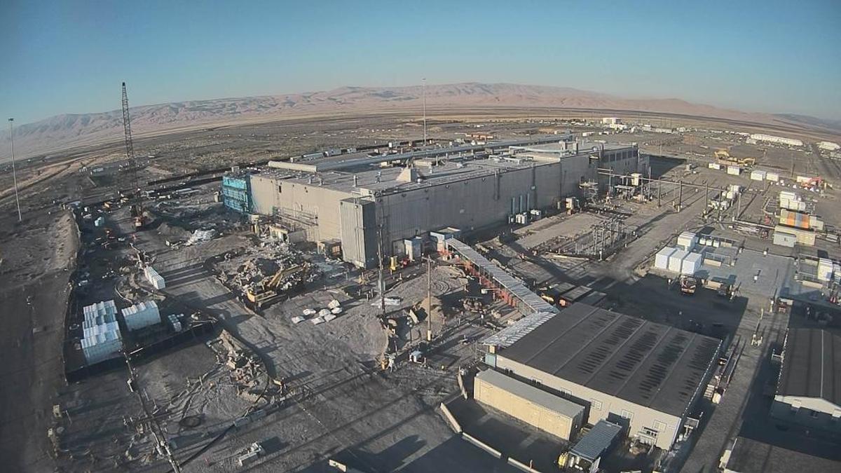 The Plutonium Finishing Plant is shown early in demolition with the Plutonium Reclamation Facility at one end covered in blue fixative to control the spread of airborne contaminants.