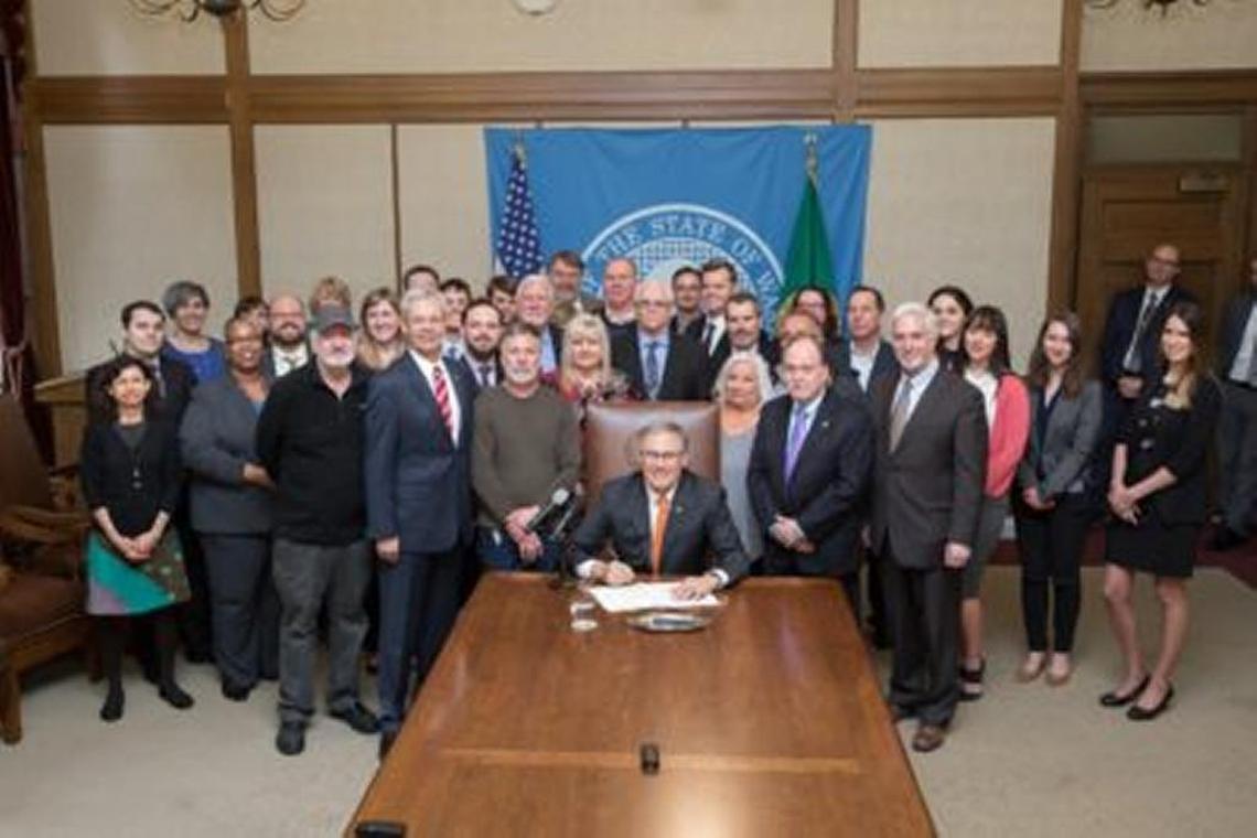 Gov. Jay Inslee signed a bill March 7 to help Hanford nuclear reservation workers win approval of state worker compensation claims. He was joined by advocates for Hanford workers, ill workers and their families.