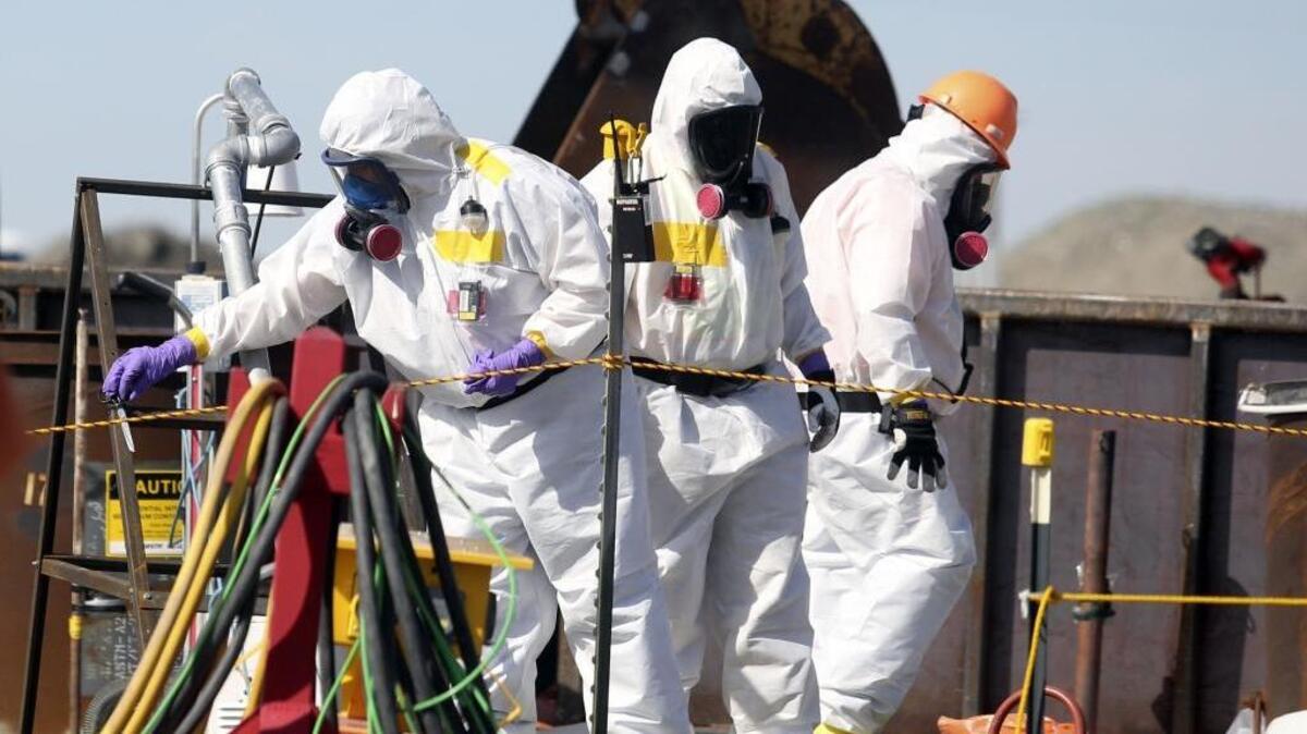 Workers remove piping for grout that was mixed Wednesday with radioactive waste from a vertically buried pipe at the Hanford 618-10 Burial Ground north of Richland.
