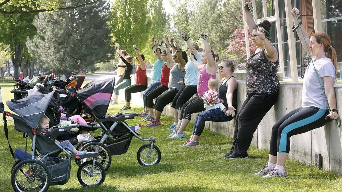 Christa Burns of Richland holds her 18-month-old daughter, Rylee, on her lap while doing the wall sit portion of Wednesday’s Stroller Strides fitness class held by FIT4MOM Richland. The class incorporates songs and activities designed to entertain and engage the children while moms complete intervals of strength and body toning exercises. The three-day-a-week class is offered at Richland’s Howard Amon Park. The business is offering free Stroller Strides classes May 8, 10 and 12. Call Abigail Macouzet at 509-581-0499 for details. Watch a video at tricityherald.com/video