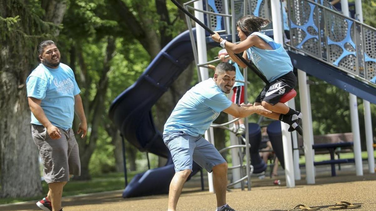 Hector Ramos laughs as he watches Jose Ramos push David Ramos on a merry-go-round swing during the second annual Ramos family reunion Saturday at the west side of Chiawana Park in Pasco. The Ramoses are from Pasco and had family coming in from California.