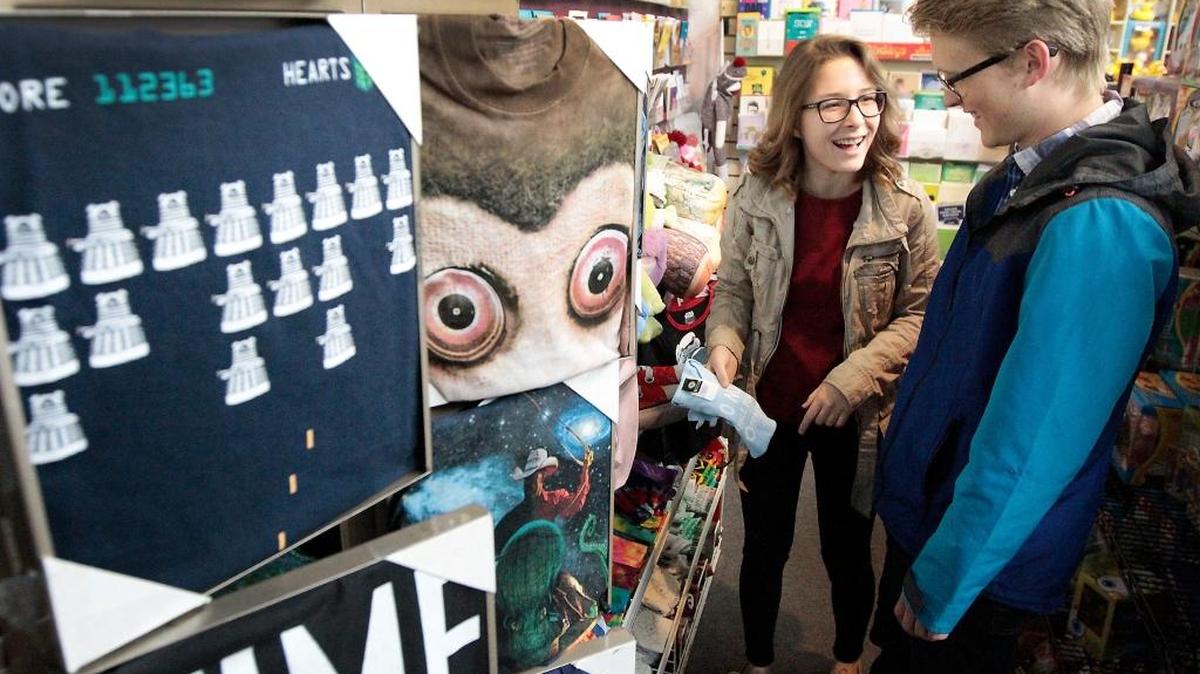 Customers Andrea Johnson, 19, left, and Tanner Phillips, 21, share a laugh at while looking at merchandise Friday morning at Octopus' Garden at the Uptown Shopping Center in Richland.