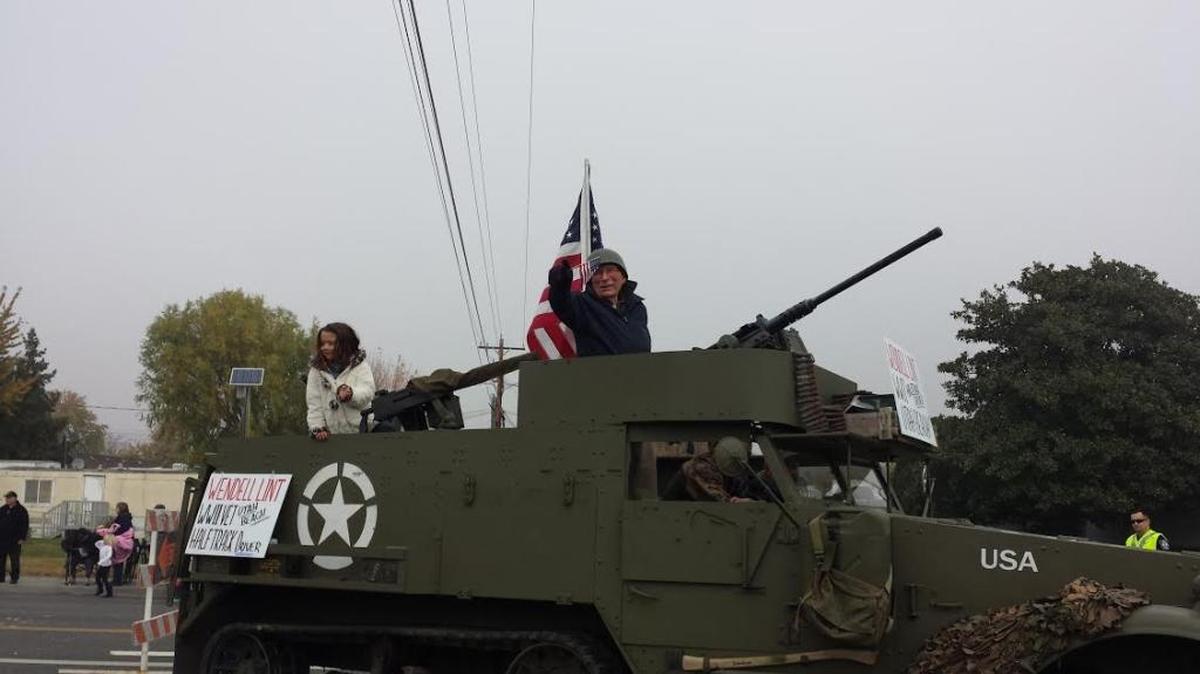Wendell Lint rides atop a half-track, similar to one he drove in World War II, during Saturday’s West Richland Veterans Day Parade.