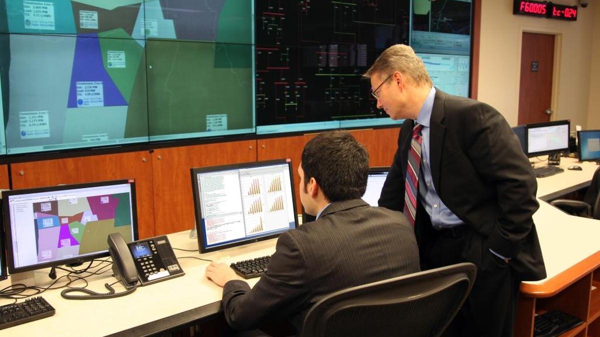 PNNL's Power Grid Integrator has demonstrated up to a 50 percent improvement in forecasting future electricity needs over several commonly used tools. Project lead Luke Gosink, right, consults on the use of the new tool.