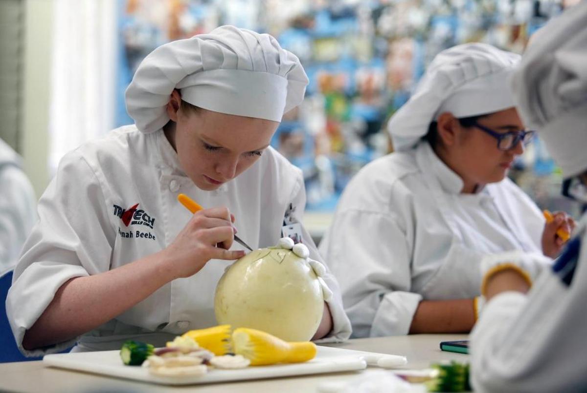 Tri-Tech Skills Center culinary arts students work on carving melons.