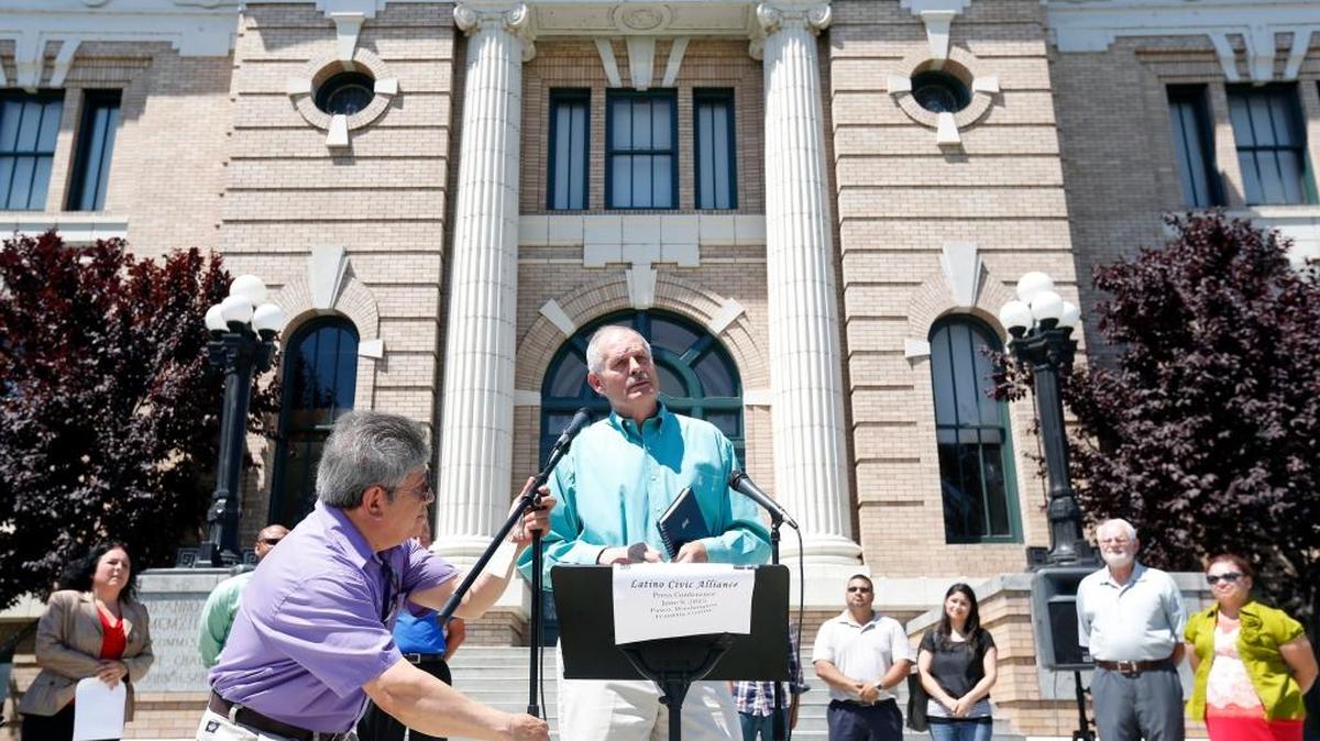 
Gabriel Portugal, board member for the Latino Civic Alliance, adjusts a microphone as former Benton County Commissioner Claude Oliver speaks during a June news conference at the Franklin County Courthouse in Pasco. The Latino Civic Alliance pushed for an outside agency to step in and investigate the Pasco police shooting of Antonio Zambrano-Montes.
