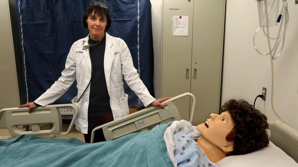 Nurse Sara Barron, seen with a simulation patient used in her teaching work with WSU, first called attention to increasing cases of anencephaly, a devastating birth defect in which babies are born missing parts of the brain and skull.