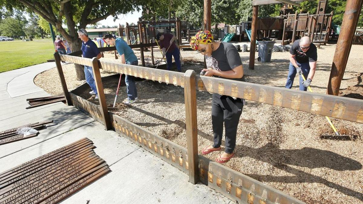 June 16, 2018 - Volunteers Mark Blotz, Nathan Burt, Toni Ball and Ken Call, from left, remove memorial pickets at Kennewick's Playground of Dreams in June during the annual George and Pat Jones Community Service Day.
