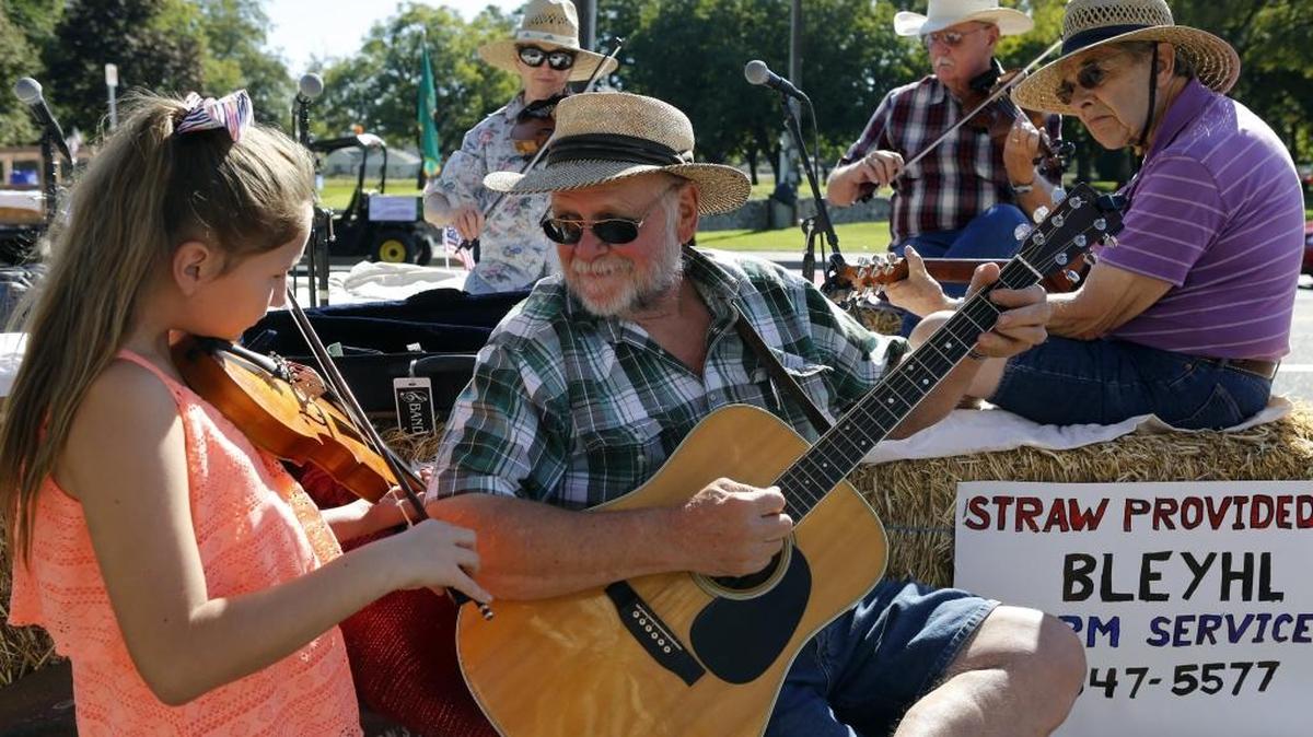 Daryl Wennecke looks at his granddaughter, Kylee Gunter, as they warm up with the Washington Old Time Fiddler group Saturday morning during the annual Benton Franklin Fair Parade through downtown Kennewick. The fair runs Aug. 23-27. See a video at tricityherald.com/video