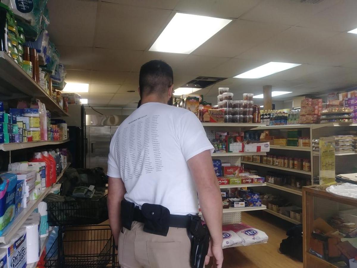 A federal agent talks with a man inside the East Africa Grocery and Halal on Tuesday. Officers did not release why they closed and searched the store. The store reopened in the afternoon.