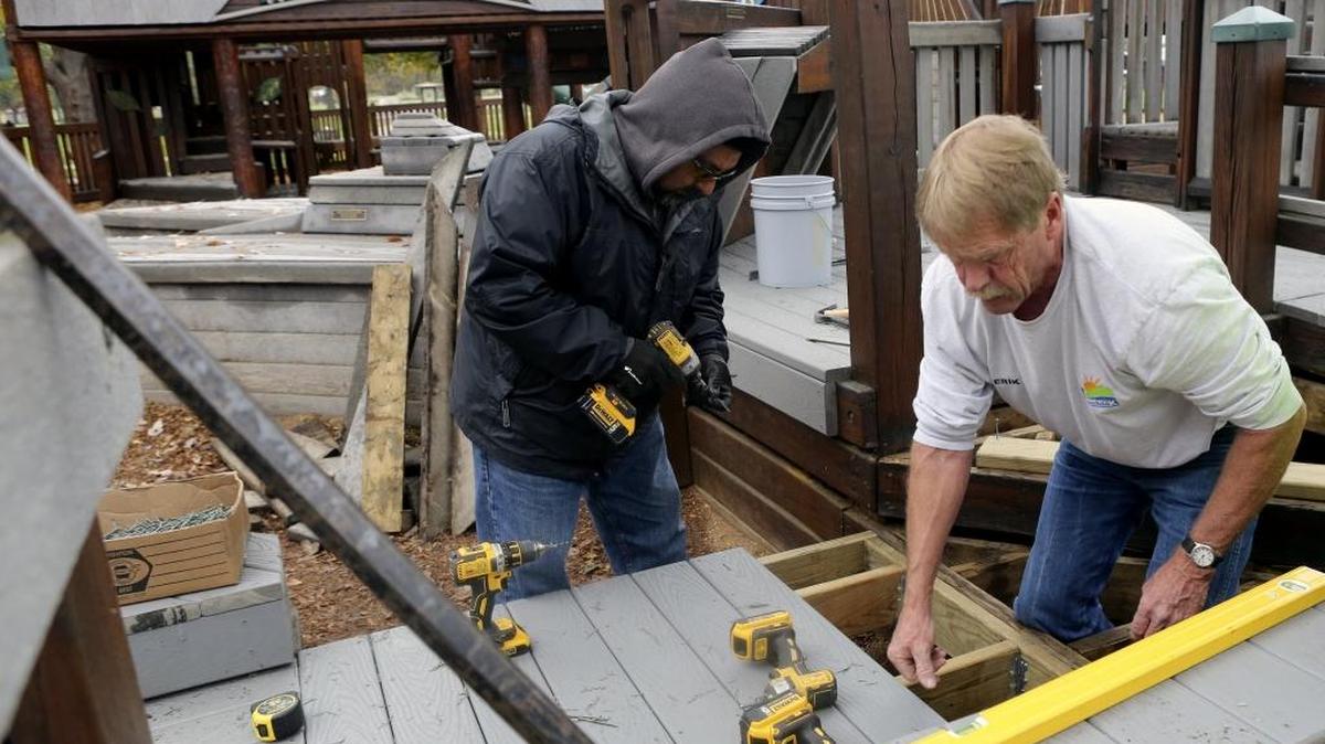 Erik Elmgren, right, and Ralph Serrato, both with the city of Kennewick, work on replacing composite decking and repairing framing at the Playground of Dreams in Columbia Park. The popular playground is scheduled to be closed for the maintenance for the next month or two.