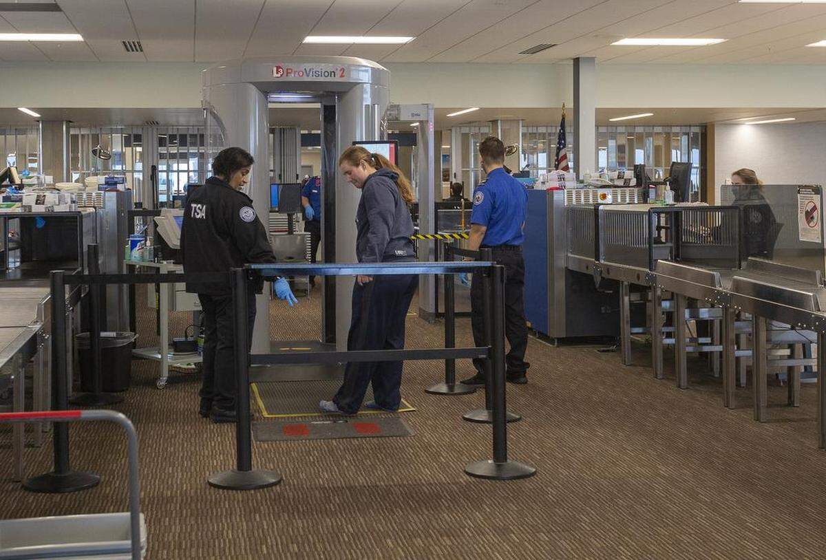 A Transportation Security Administration (TSA) agent checks a woman inside the Tri-Cities Airport in Pasco. TSA agents continue to work without a paycheck during the government shutdown.
