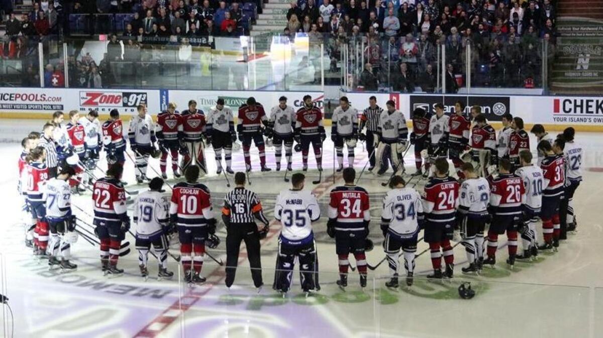 The Tri-City Americans and Victoria Royals stand in unity prior to Saturday’s playoff game in Victoria, British Columbia. The teams also have Humboldt Broncos stickers on their helmets.