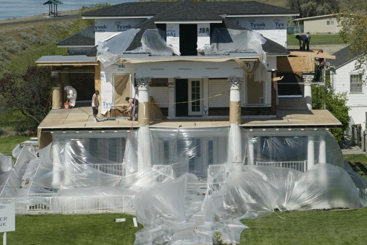 Reconstruction continues April 22, 2005, on the Moore Mansion in Pasco as workers prepare to weatherproof the decking. A fire in 2001 severely damaged the iconic home.