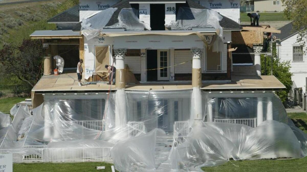 Reconstruction continues April 22, 2005, on the Moore Mansion in Pasco as workers prepare to weatherproof the decking. A fire in 2001 severely damaged the 96-year-old icon. Owners Brad and Debra Peck bought the mansion March 2004 and have been working to rebuild it.