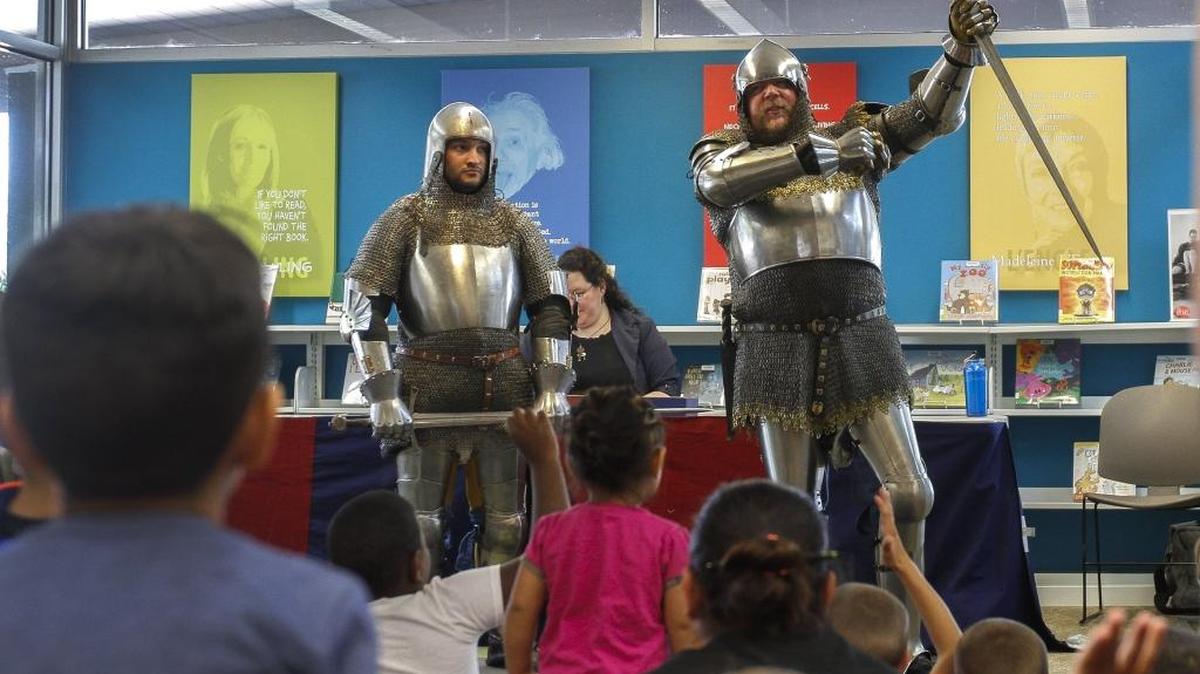 Children watch as Knights of Veritas members Eric Slyter, left, and Michael Jones show some medieval weaponry and talk about knighthood, armor, combat and chivalry on Thursday at the downtown Pasco branch of the Mid-Columbia Libraries. The group is based in Ellensburg and gives demonstrations around the Northwest.