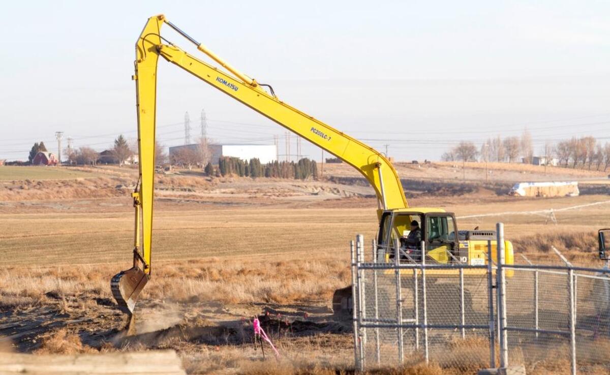 A worker distributes dirt in 2013 to repair soil cracks at the Pasco Sanitary Landfill, where an underground fire burned for two years before an underground wall was built around the burning area.