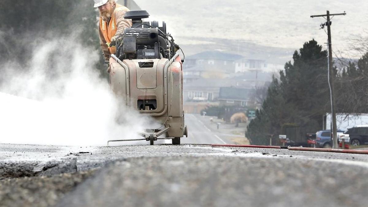Jeff Miller of A-Core Concrete Cutting maneuvers a water-cooled circular blade-cutting machine Friday along South Vancouver Street near West 37th Avenue in Kennewick. The work is in preparation for an installation of an underground pressurized pipeline to replace an existing gravity pipeline for the Kennewick Irrigation District. The roadway will have temporary daytime closures in three phases, between West 36th and West 45th avenues, starting Jan. 12 and lasting until Feb. 22. Road closures will re-open each night, according to KID. Motorists will be directed by detour signs and reader boards posted in the area during the project.