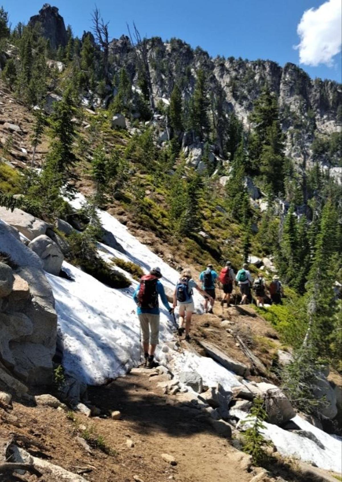 Members of the Intermountain Alpine Club cross a snowbank below Angell Pass above Anthony Lake.