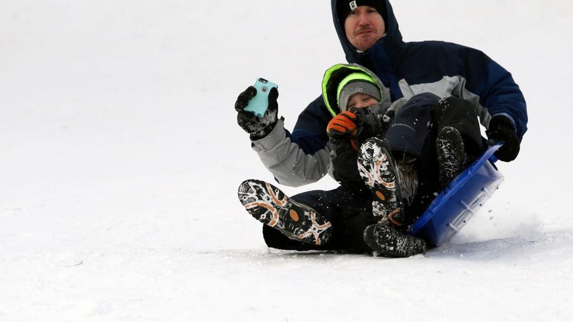 Charles Rutherford, of Richland, holds on to his phone as he and his son Zachary, 6, loose their balance Thursday while sledding down Carmichael Hill in Richland. "We've been sledding twice in the last week, I think that's a new record," Charles said of recent snow days local schools have had.