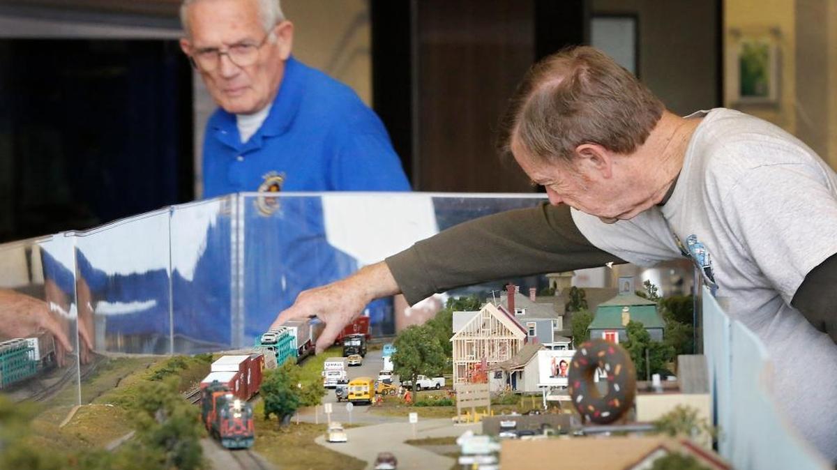 Bob Jekel, a longtime member of the Tri-City Model Railroaders, re-aligns the wheels of a railroad car that jumped the tracks Monday while setting up the club's exhibit at The Reach center in Richland. Club president John Pettigrew, left, also helps setting up the 20-foot by 28-foot modular display which is scheduled through January 28. Admission into the interpretive center is: $8 adults, $6 seniors (65+) and students (6-18), $ military and Reach members are free.
