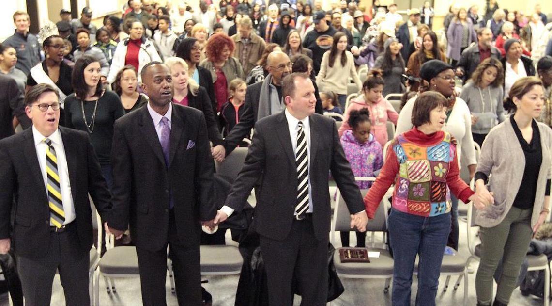 Judge Salvador Mendoza Jr., center, joins hands as the audience at the 2016 annual Martin Luther King Jr. bell-ringing ceremony sings “We Shall Overcome” at Columbia Basin College in Pasco.