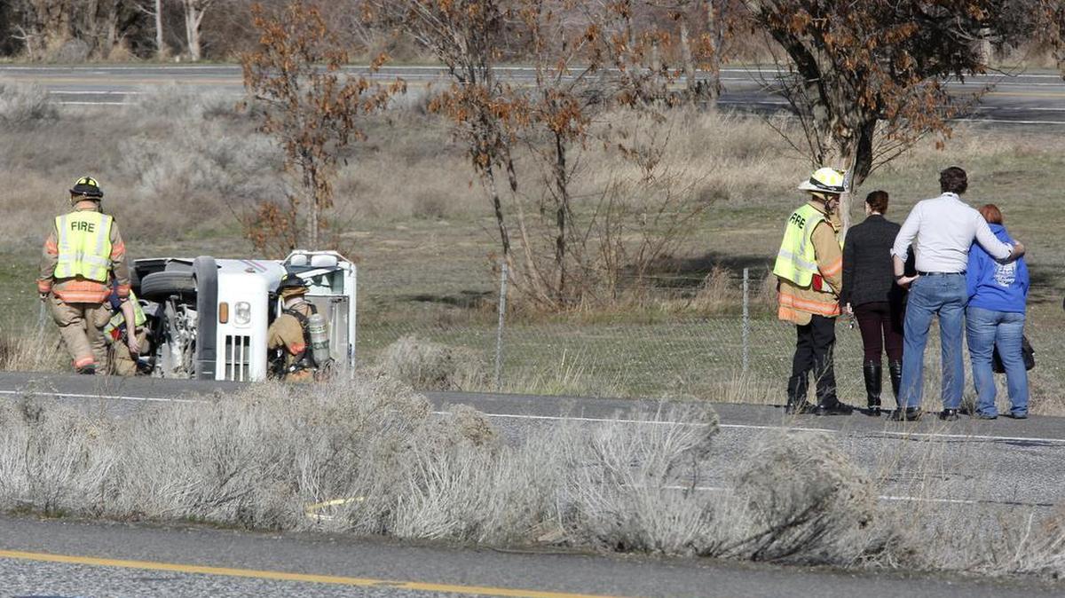 Kennewick firefighters check an overturned mail delivery Monday morning in the westbound lanes of Highway 240 near the Edison Street overpass. The delivery vehicle caught fire after the wreck and was put out by police officers using fire extinguishers.