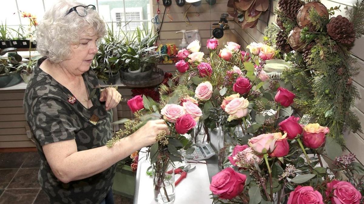 Floral designer Trish Misczuk keeps busy Friday arranging displays of roses for a Valentine’s weekend wedding and other customer orders at Heritage Floral in Kennewick. Many of the delivery orders are earlier than normal this year because the holiday falls on a Sunday. The Kennewick business, which relocated last month to West 27th Avenue and South Ely Street, changed its hours to be open Sunday for last-minute purchases.