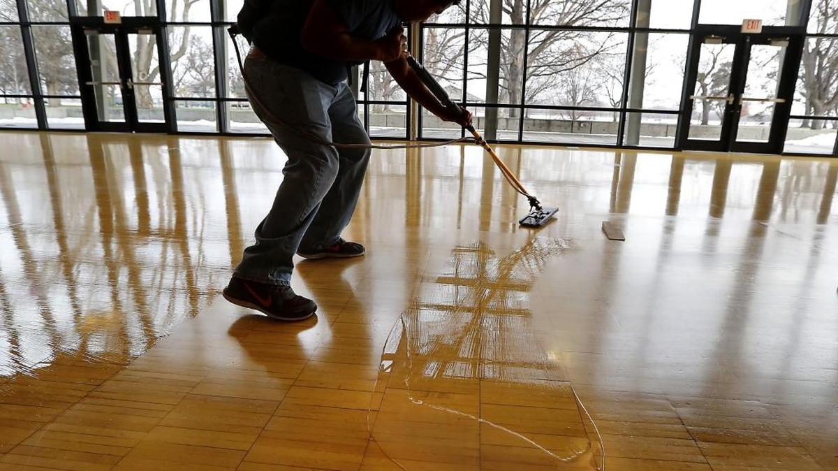 Fernando Aguilar, an employee of American Building Maintenance, is silhouetted in the Riverview Room at the Richland Community Center on Thursday as he spreads an even layer of a glossy sealant on the wood floor. The building is temporarily closed for maintenance projects, including repainting walls, re-grouting tile flooring, resurfacing wood floors and expanding the exercise facility. The center reopens at 8 a.m. on Dec. 26. It’s also closed New Year's Day and Jan. 2.