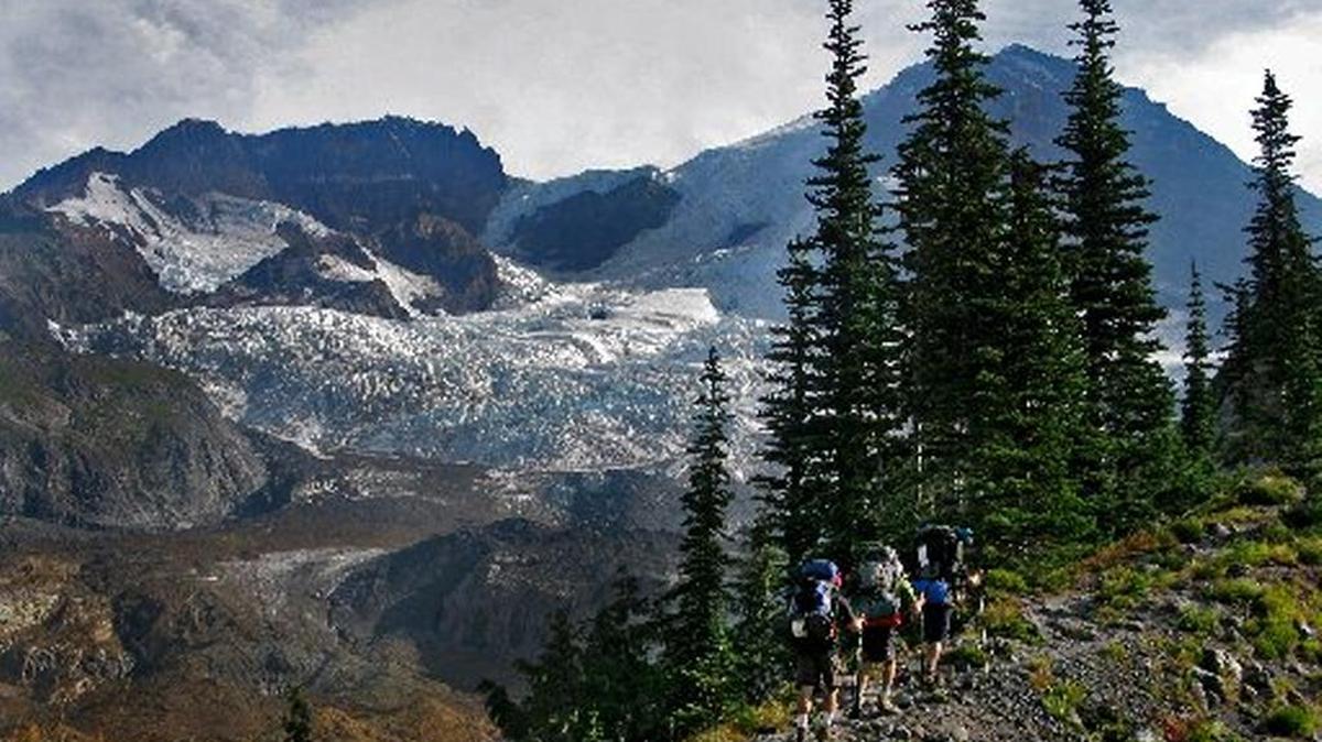
With Mount Rainier in the distance, people hike toward the Tahoma Glacier on the Wonderland Trail at Mount Rainier National Park.
