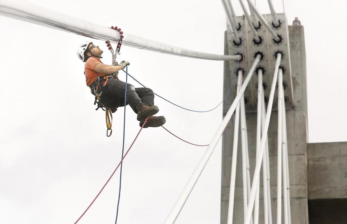 A Washington State Department of Transportation employee rappels 180-feet from a support tower for the cable bridge in 2018 during a visual inspection of the cables supporting the span across the Columbia River.
