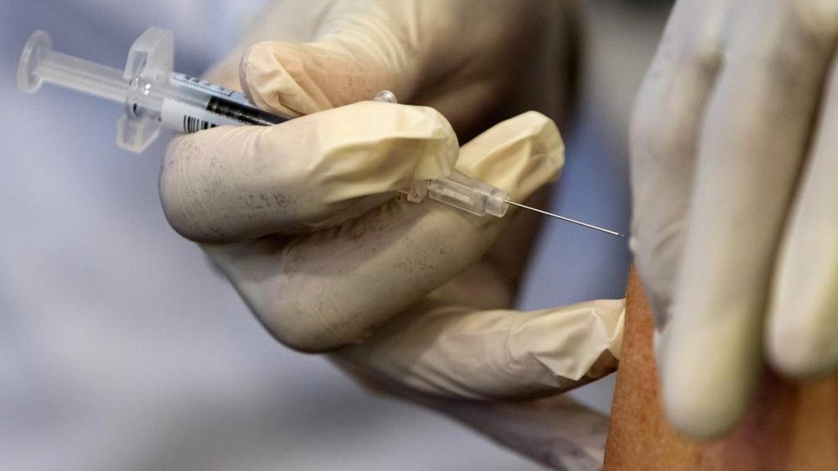 Flu continues to pummel the Tri-Cities, with 16 local flu deaths now reported. This file photograph shows a nurse administering a flu vaccine in Washington.