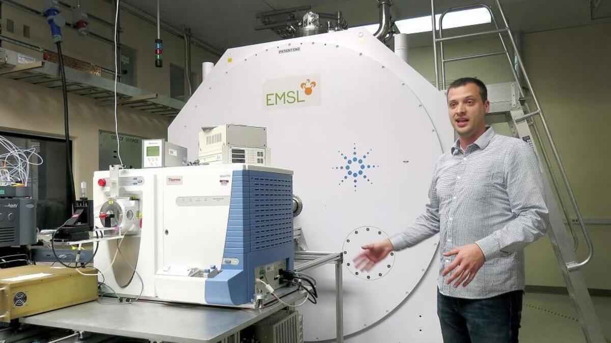 Scientist Jared Shaw discusses the 21T, a powerful magnet, shown behind him, coupled with an ultra-high resolution mass spectrometer, at the Environmental Molecular Sciences Laboratory in Richland.
