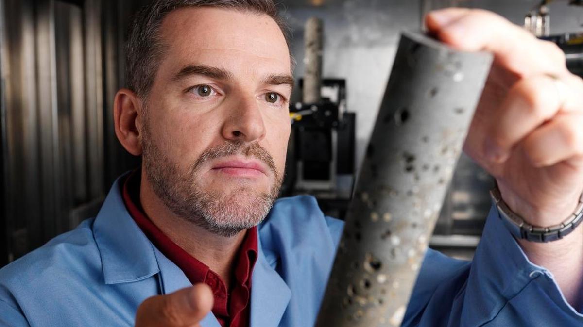PNNL scientist Pete McGrail is part of a team studying basalts to determine if carbon dioxide can be safely and permanently stored in these massive, deep underground rock formations. In this photo, he examines a basalt core sample.