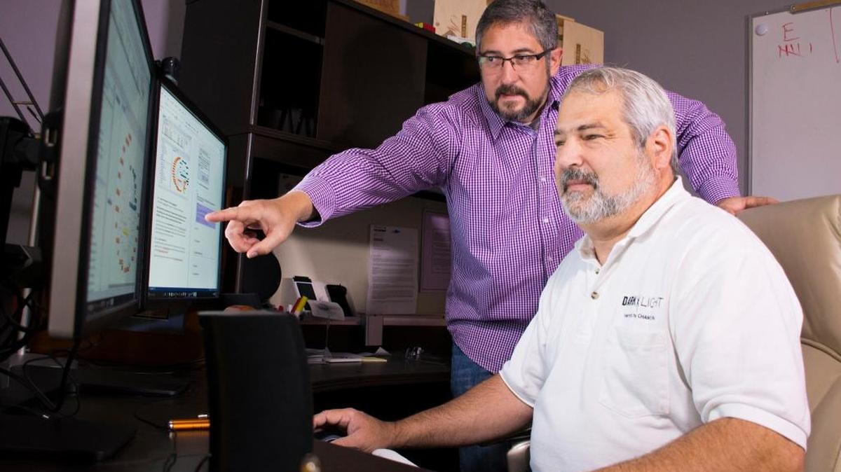 Pacific Northwest National Laboratory’s Shawn Hampton, left, and former PNNL employee Ryan Hohimer, now with Champion Technology Company Inc., look over cybersecurity software that they helped develop and that is available from Champion Technology. The effort to commercialize this technology was recognized by the Federal Laboratory Consortium with a 2016 Excellence in Technology Transfer award.